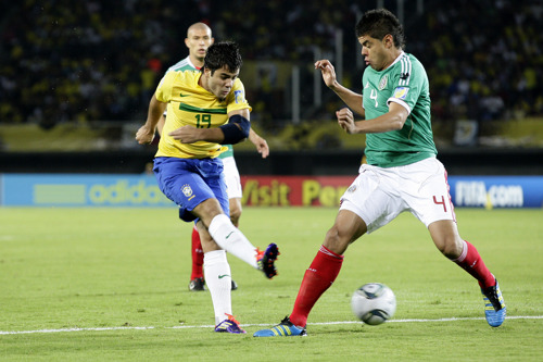 Henrique Almeda, scorer of both goals for Brazil, clashes with Néstor Araujo of Mexico in the semifinals of the FIFA U-20 World Cup in Pereira, Colombia, on August 17, 2011.